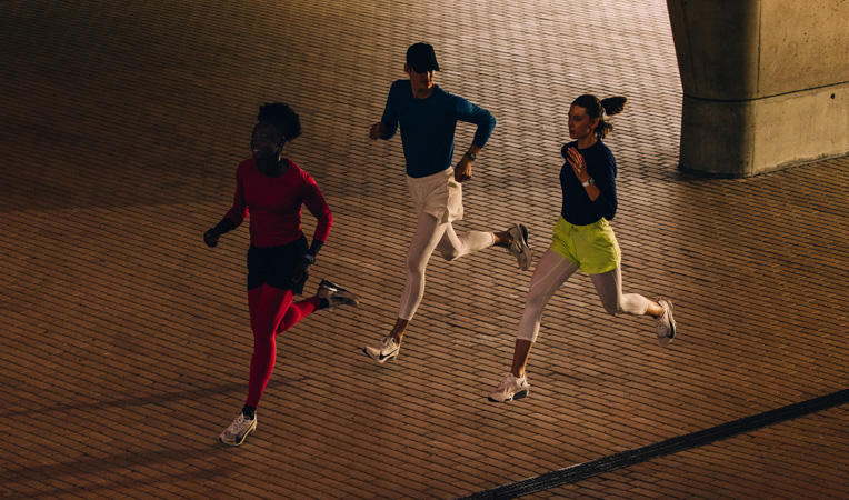 Trois personnes courant ensemble, des Apple Watch au poignet