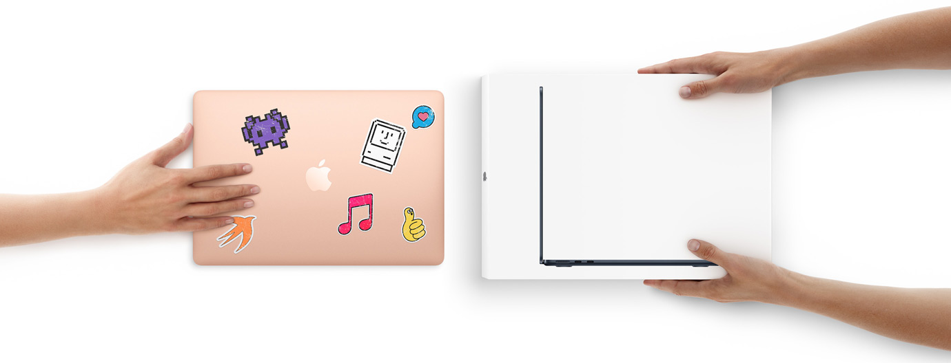 Una mano acerca un MacBook con stickers en la cubierta hacia otras dos manos que sostienen un MacBook nuevo dentro de su caja