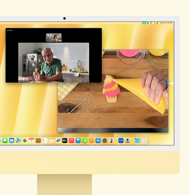iMac amarilla. Demostración de Vista del Escritorio. La pantalla muestra una videollamada entre la repostera y otra persona. Una pantalla muestra los rostros de la repostera y el hombre, mientras que la otra muestra las manos de la repostera glaseando una galleta