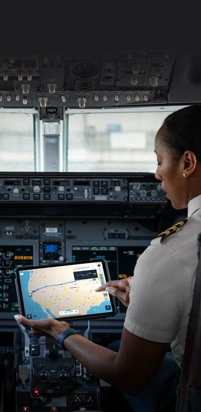 Pilotka w kokpicie patrząca na mapę na ekranie iPada.