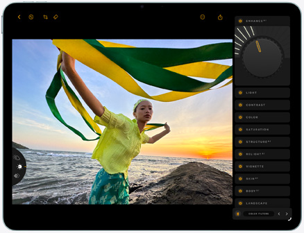 جهاز iPad Air، الجانب الأمامي الخارجي، تعديل صورة لشخص يحمل قطعة قماش خضراء وصفراء على خلفية شاطئ تخيّم عليه أشعة الغروب، وأدوات التعديل ظاهرة على الجانب الأيمن