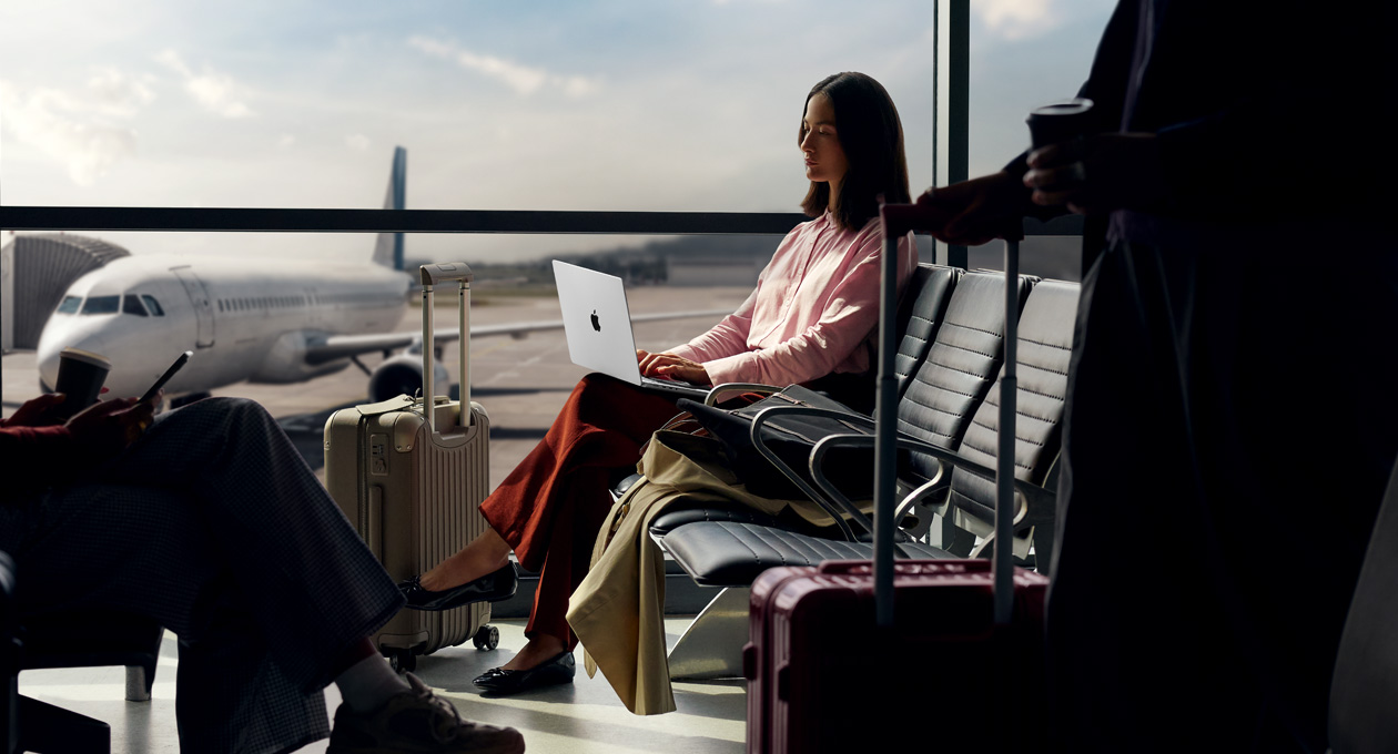 A person at an airport using their MacBook Pro